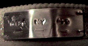 Close-up photograph of the "Kiss My Ass" aluminium label on Ju's spinal brace