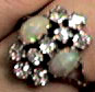 Close-up photograph of a ring, with two opals surrounded by nine diamonds